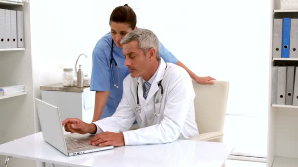 Doctor using computer keyboard at desk — Stock Video