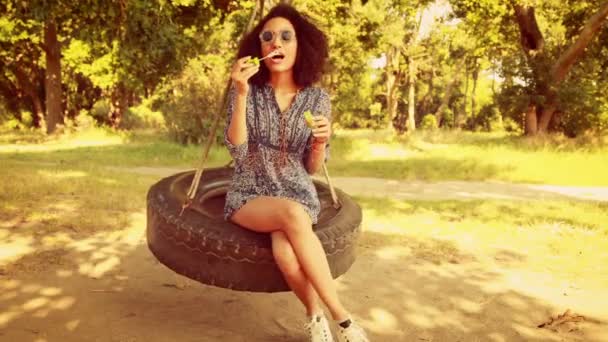 Pretty young woman in tire swing — Stock Video