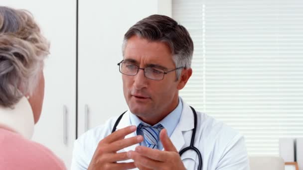 Doctor speaking with his patient at desk — Stock Video