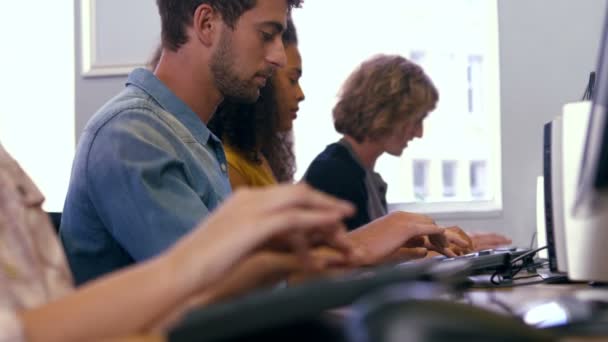 Студенты, использующие компьютеры в компьютерной комнате — стоковое видео