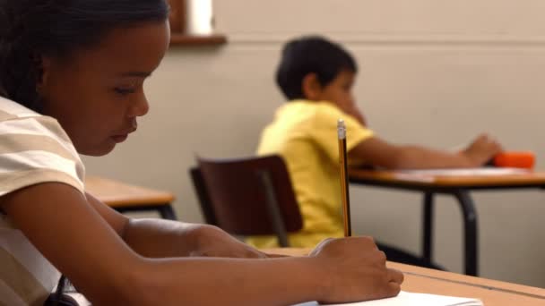 Criança escolar escrevendo em bloco de notas na escola — Vídeo de Stock