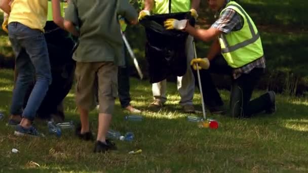 Famille ramassant des ordures dans le parc — Video