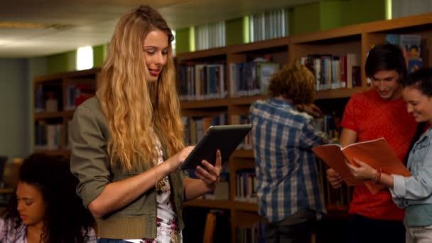 Estudiante usando tableta en biblioteca — Vídeo de stock