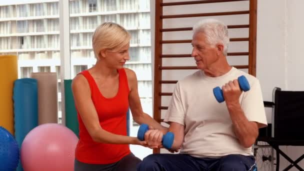Tränare att hjälpa senior citizen träna — Stockvideo
