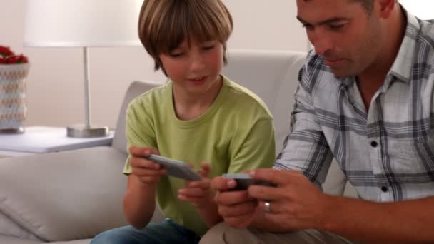 Батько і син грають в ігри по телефону — стокове відео
