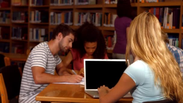 Estudiantes trabajando juntos en la biblioteca — Vídeo de stock