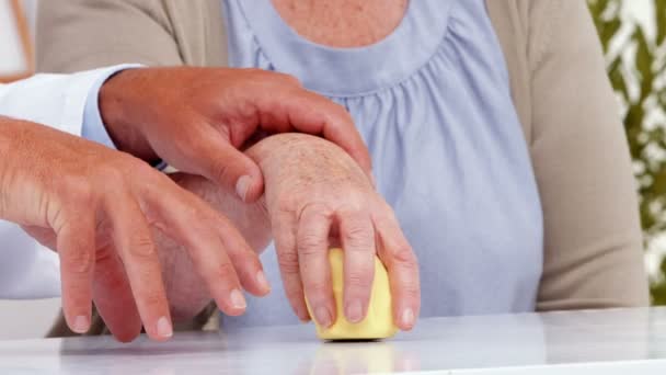 Doctor showing patient how to exercise injured hand — Stockvideo