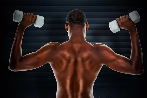 Composite image of rear view of a fit shirtless man lifting dumb — Stock Photo, Image