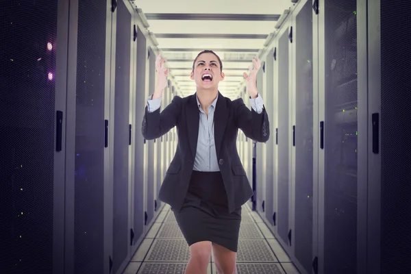 Сердитая деловая женщина жестом против центра обработки данных — стоковое фото