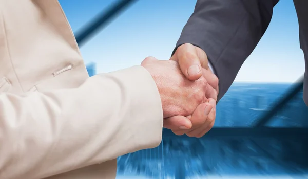 Business people shaking hands against large window — Stock Photo, Image