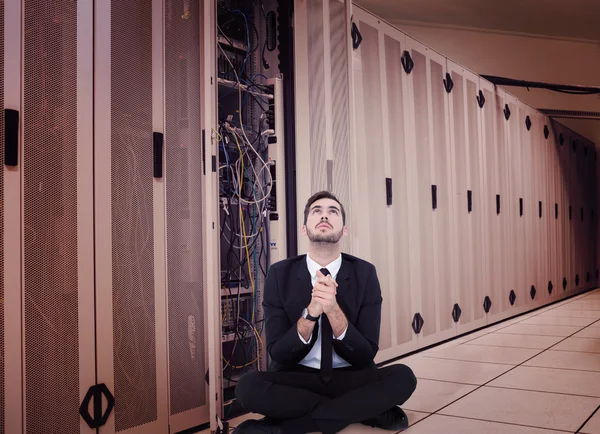 Businessman sitting praying and looking up — Stock Photo, Image