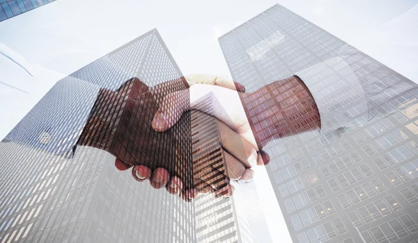 Handshake in office against skyscraper — Stock Photo, Image