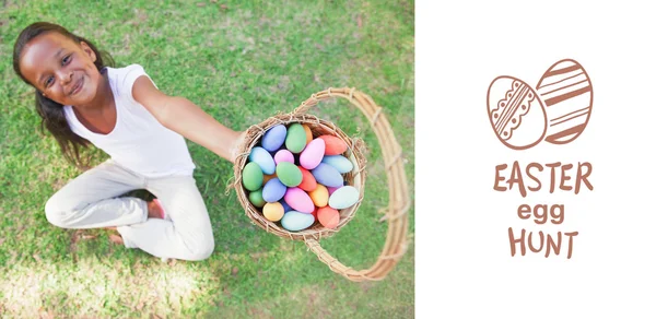 Girl showing basket of easter eggs — Stock Photo, Image