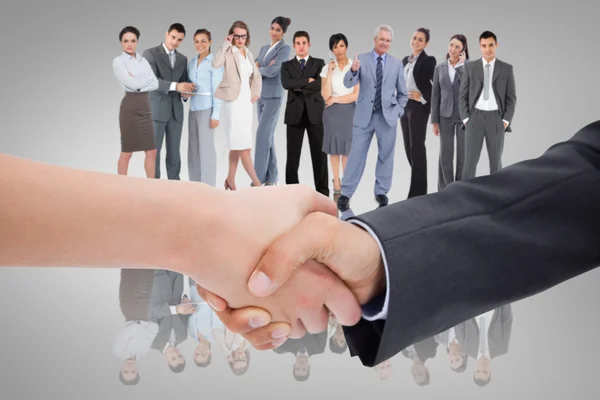 Handshake against business team — Stock Photo, Image