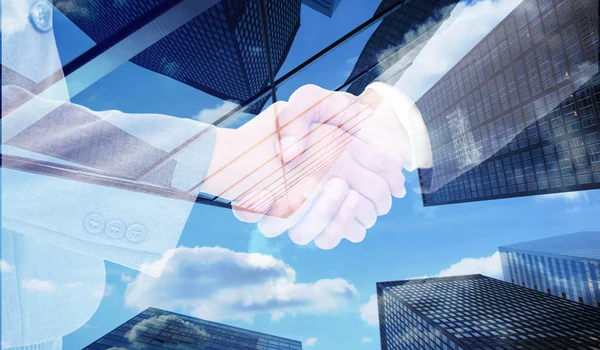 Handshake between business people against skyscraper — Stock Photo, Image