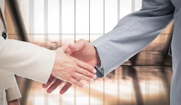 Business people shaking their hands against large window — Stock Photo, Image