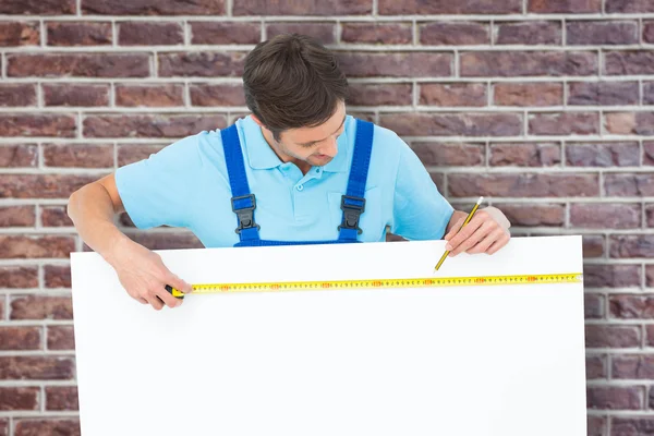 Carpinteiro que mede a placa branca da conta — Fotografia de Stock