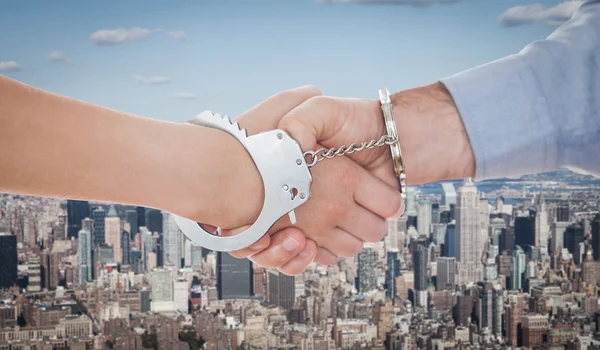 Handcuffed business people shaking hands — Stock Photo, Image