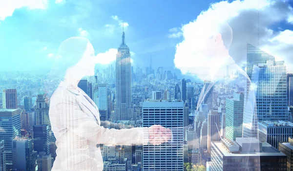 Future partners shaking hands against city skyline — Stock Photo, Image