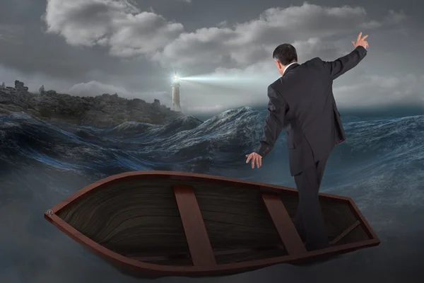 Businessman balancing in boat against stormy sea — Stock Photo, Image