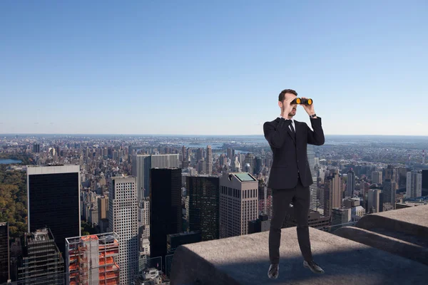 Hombre de negocios de pie y usando prismáticos — Foto de Stock