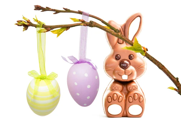 Hanging easter eggs against chocolate bunny — Stock Photo, Image