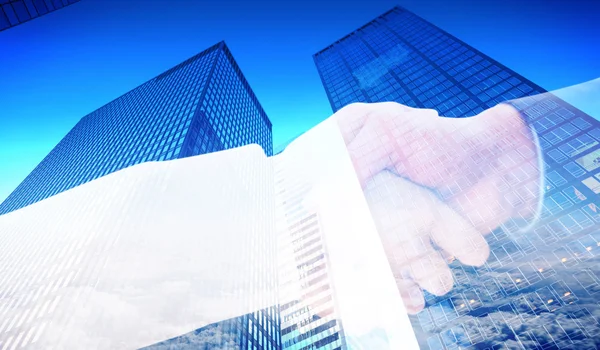 Partners shaking hands against skyscraper — Stock Photo, Image