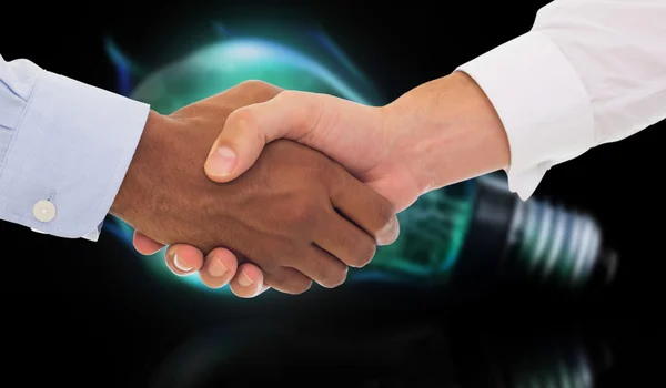 Handshake in office against glowing light bulb — Stock Photo, Image