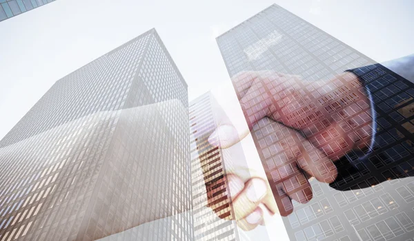 Partners shaking hands against skyscraper — Stock Photo, Image