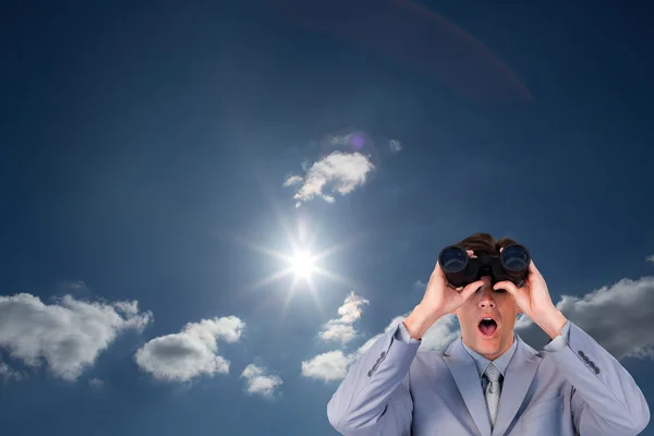 Hombre de negocios sorprendido mirando a través de prismáticos —  Fotos de Stock