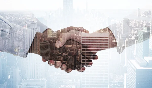 Handshake against city skyline — Stock Photo, Image