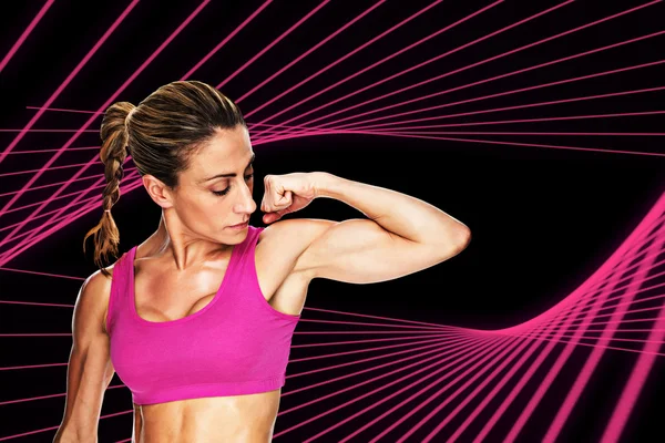 Bodybuilder buigen biceps in roze sport-BH — Stockfoto