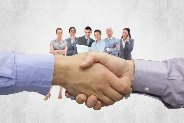 Hand shake against business team — Stock Photo, Image