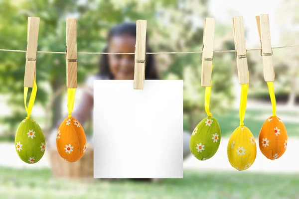 Hanging easter eggs against girl sitting on grass — Stock Photo, Image