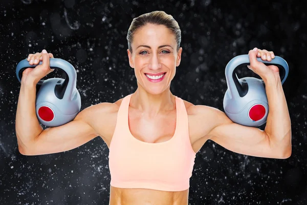 Feliz mujer crossfitter levantamiento kettlebells — Foto de Stock