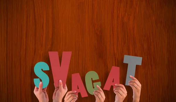 Hands holding up svagat against table — Stock Photo, Image