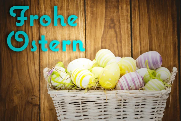 Velikonoční vejce v košíku proti frohe Velikonoce — Stock fotografie