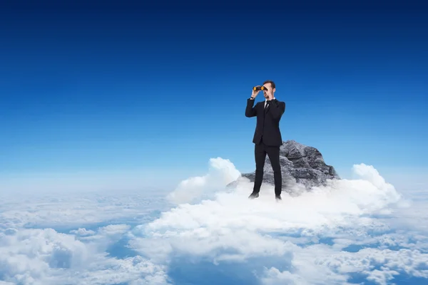 Businessman standing and using binoculars — Stock Photo, Image