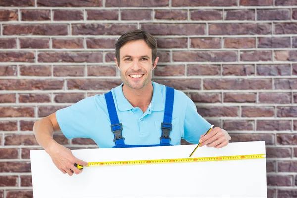 Carpenter measuring blank bill board — Stock Photo, Image