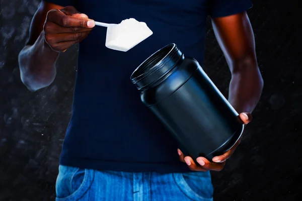 Mid section of man holding a scoop of protein — Stock Photo, Image