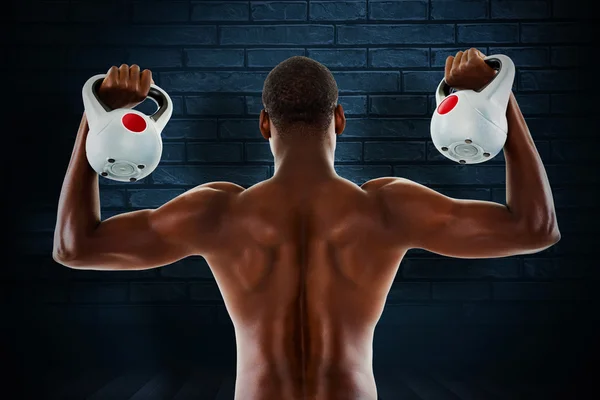 Composite image of rear view of shirtless fit man lifting kettle — Stock Photo, Image