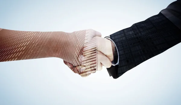 Handshake against low angle view of skyscrapers — Stock Photo, Image