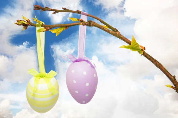 Hanging easter eggs against cross — Stock Photo, Image