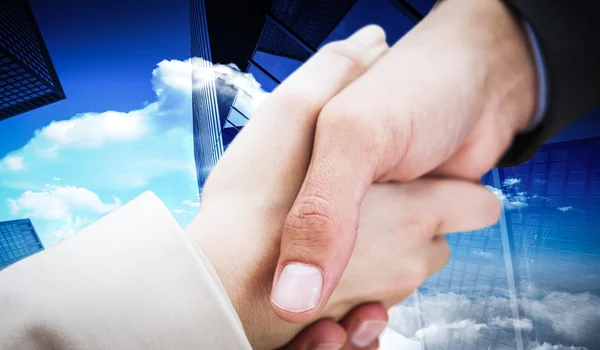 Nuevos socios estrechando la mano contra el rascacielos —  Fotos de Stock