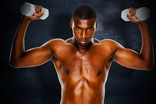 Composite image of determined fit shirtless man lifting dumbbell — Stock Photo, Image