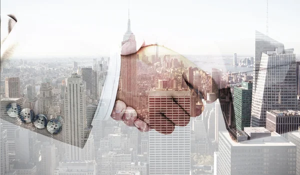 Business peoples hands shaking against city skyline — Stock Photo, Image