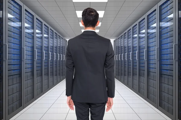 Businessman against server hallway — Stock Photo, Image