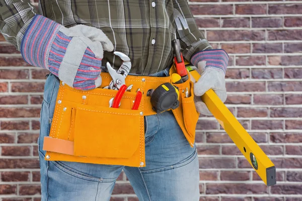 Handyman holding spirit level — Stock Photo, Image