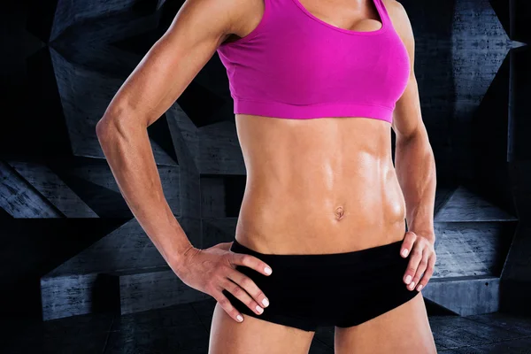 Vrouwelijke bodybuilder poseren met de handen op de heupen — Stockfoto
