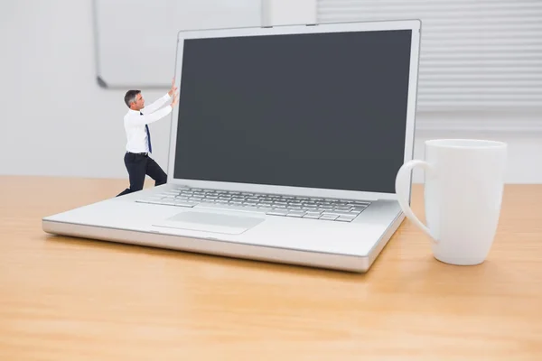 Бизнесмен, толкающий компьютер — стоковое фото
